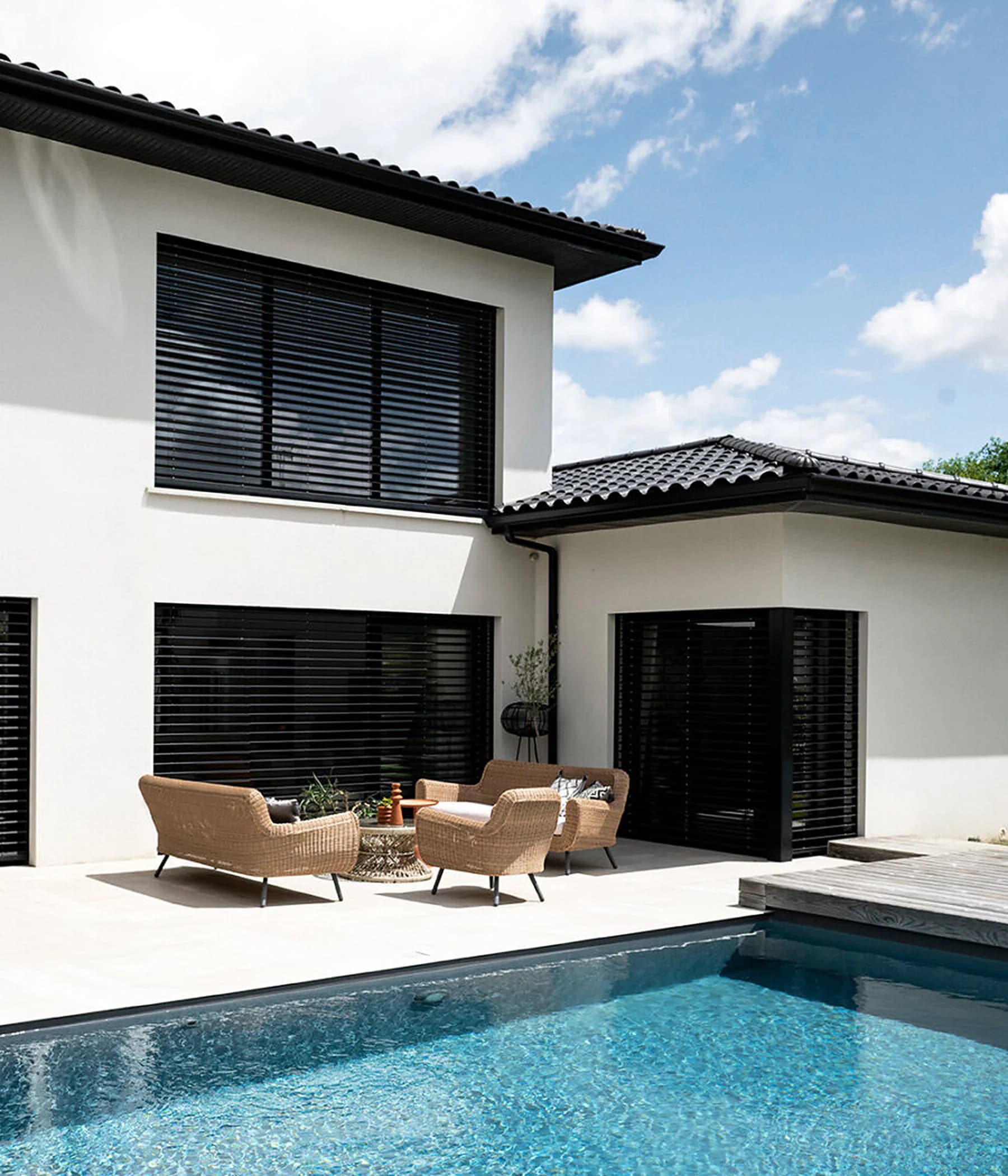 Villa mit schwarzen Lamellenstoren und Pool